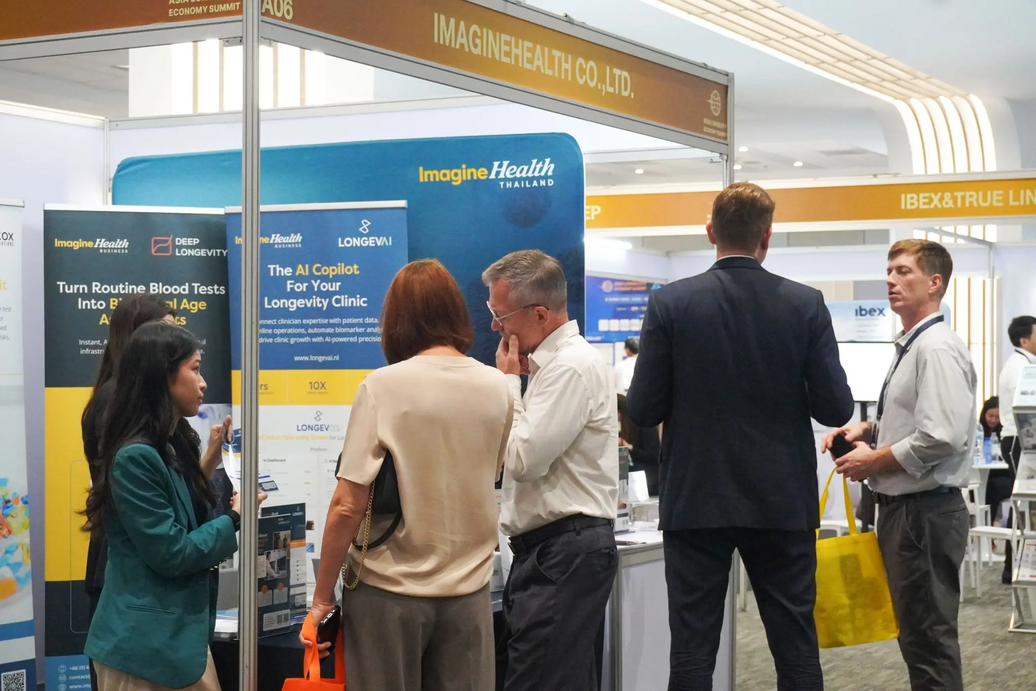 Visitors in conversation at the ImagineHealth booth during the Asia Longevity Economy Summit